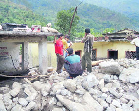 Villagers stand outside their homes, inundated by debries and mud, following a cloudburst in the Choribagar area of Pithoragarh district.