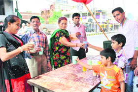 Passersby enjoy sweetened water at a chabeel in Rohtak.
