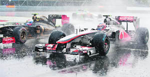 Vitaly Petrov attempts to overtake Mclaren Mercedess Jenson Button in heavy rain during the Canadian Formula One Grand Prix in Montreal 