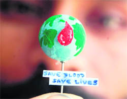 Paper artiste Gurpreet Singh holds his creation to promoto blood donation on the occasion of World Blood Donor Day in Amritsar