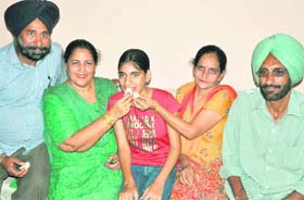 Celebration time Navneet Kaur, who scored 64th rank in the Class X PSEB examination, celebrates wtih her parents and school principal