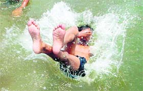 A boy jumps into a swimming pool to cool himself from the heat in Chandigarh