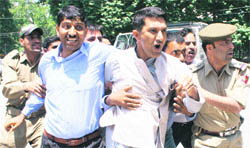Policemen detain protesting members of the Jammu and Kashmir Teachers Forum in Srinagar on Tuesday