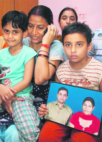Madhu Sharma, wife of released Merchant Navy officer Narottam Kumar Sharma, with her children at her home in Jammu on Tuesday