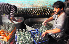 Workers busy cleaning and filling bottles of a local soft drink, popularly known as banta bottle, in Jammu. Despite concerns regarding hygiene, the soft drink registers high sale in summer. 