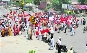 Members of trade unions stage a protest at Bharat Nagar Chowk in Ludhiana on Tuesday. 