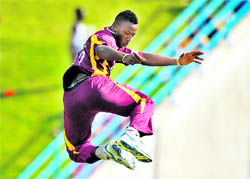 West Indies Andre Russell leaps in the air to celebrate the dismissal of Praveen Kumar in St Johns on Monday