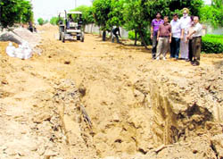 Residents of Sukhmani Enclave show the ongoing sewerage project in Ludhiana on Wednesday