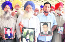 Family members show pictures of the missing youths, in Jalandhar on Wednesday