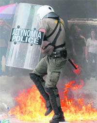 A riot policeman dodges a Molotov cocktail (petrol bomb) thrown by demonstrators during anti-austerity protests in Athens 
