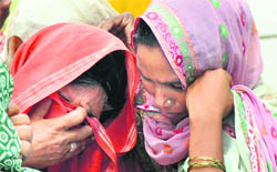 The mother (left) and a kin of the teenaged girl mourn her death in Karnal 