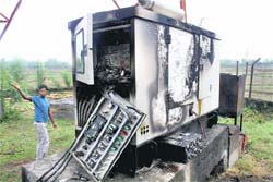 A man stands near the mobile tower machine that was set afire by the Maoists in Gaya 