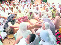 Relatives grieve over the death of Harjit Singh, a victim of racial attack in England, at Kallha village in Tarn Taran on Friday