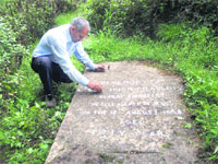 Local historian Gopal Bhardwaj removes dirt from the grave of Lt. Col Hugh Fraser, the slayer of Rani of Jhansi, at Mussoorie. 