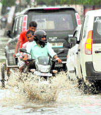 Motorists wade through a flooded road after a downpour in Gurgaon on Friday