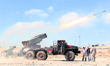 Rebel fighters fire a rocket at the city of Misrata on Friday