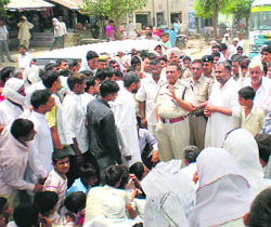 The police tries to convince villagers to lift their road blockade at Samain in Fatehabad on Saturday.