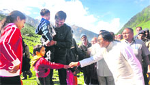 Uttarakhand Chief Minister Ramesh Pokhriyal Nishank shakes hands with a young pilgrim on the way to the Kedarnath shrine on Sunday.