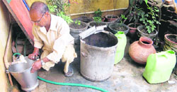 A man waits for water supply to start at his residence in Ward No. 14 of Dehradun.