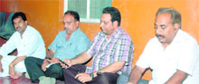 Mayor Vinod Chamoli (second from right) sits in protest in Dehradun on Monday; and (right) the dais at Gandhi Park being razed by the Municipal Corporation staff.