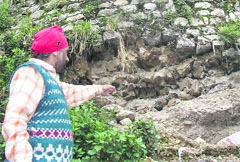 Social activist Anant Pal Singh shows a damaged embankment on south road in Mussoorie.