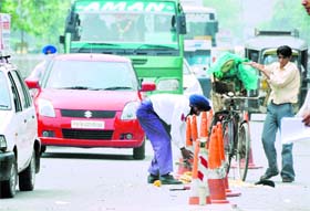 A traffic policeman offers help to a ‘papad’ vendor on the busy Bharat Nagar Chowk in Ludhiana on Monday .