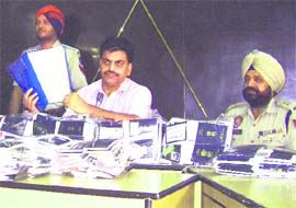 Nawanshahr SSP Dr Narinder Bhargava shows bunches of passports and other documents recovered from an inter-state gang by the police on Monday.