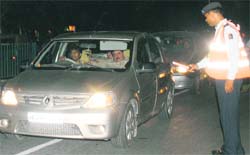 A traffic policeman signals a car to stop for checking.