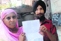 An aggrieved family shows a notice, issued by GMADA, at their house in Phase XI, Mohali,