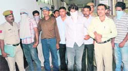 The accused (faces covered) in the Berkeley robbery case being taken to the District Courts in Sector 1, Panchkula