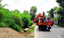 A truck dumps debris along a road at Bindravan near Palampur damaging the retaining wall