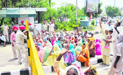 The protesting daily wagers under the MNREGA scheme outside PAU gate number 2 in Ludhiana on Tuesday