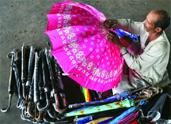An umbrella vendor with his colourful ware in anticipation of rains