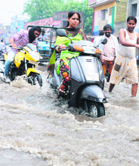Motorists have a tough time negotiating the flooded Railway road after a downpour in Karnal on Wednesday