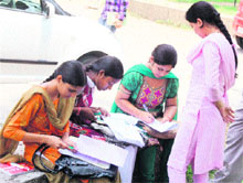 Candidates fill admission forms at the University of Jammu on Wednesday. 