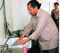 Dr Satish Aggarwal cleans utensils at Ambala Civil Hospital.