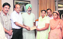 PSPCL Director (Administration) Gurbachan Singh Bachi distributes cheques among pensioners during a pension adalat in Jalandhar on Tuesday.