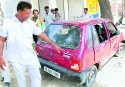 A man shows a bullet mark on the victims car