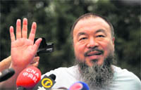Outspoken Chinese artist Ai Weiwei waves to reporters outside his studio in Beijing on Thursday. 
