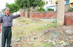 A person points towards shops constructed on encroached land in Samalkha