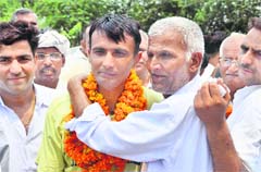 Ravinder Singh being welcomed by his father at Laadpur village in Haryana.