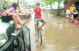 A hawker delivers newspaper to a girl on a flooded street of Mohali on Saturday morning. 