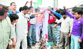 Members of the Valmiki community burn hoardings featuring Haryana Speaker Kuldeep Sharma in Karnal on Sunday.