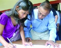 A student fills in form with the help of her father at the Faculty of Arts in Delhi University