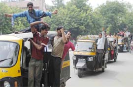 Autorickshaw drivers shout slogans demanding a hike in the fares in Faridabad