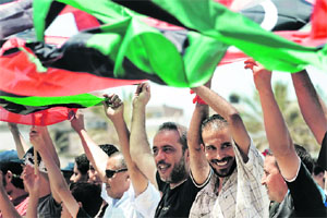 Libyans celebrate and hold up the rebel-adopted former Libyan monarchy @@flag at Misrata's Freedom Square on Monday. 