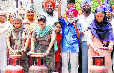 Housewives cook food in the middle of a road in protest against hike in LPG prices in Amritsar.