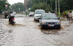 Vehicles wade through a waterlogged street in Faridabad on Tuesday.