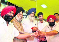 Jagdish Singh Jhinda (blue turban), president of the Sarv Pardesh Gurdwara Management Committee, is honoured at a function in Dehradun on Tuesday