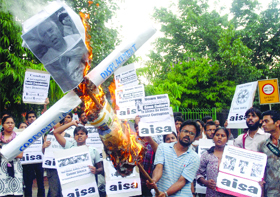 Members of the All-India Students Association burn effigies of Prime Minister Manmohan Singh and HRD minister Kapil Sibal during a protest against corruption in New Delhi on Wednesday